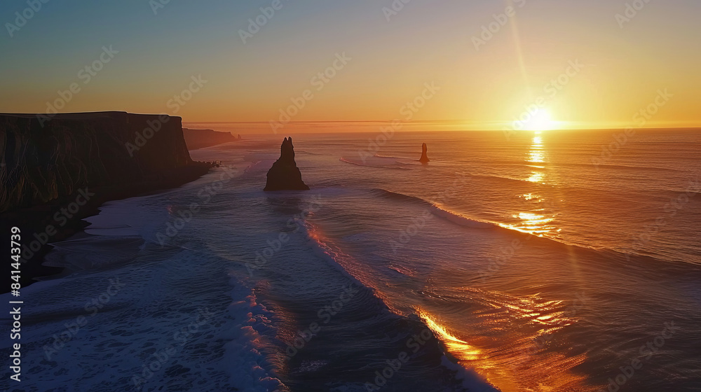 Obraz premium Stunning sunset over Reynisfjara beach with dramatic cliffs and ocean waves