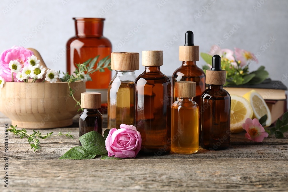 Aromatherapy. Different essential oils and flowers on wooden table Aromatherapy. Different essential oils and flowers on wooden table