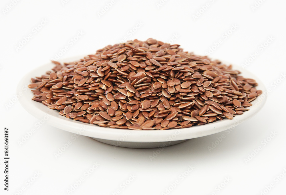 Brown flax seeds on white plate isolated on white background. Brown Flax Seed is rich in nutrients such as dietary fiber and essential fatty acids that are beneficial to the body. Brown flax seeds on white plate isolated on white background. Brown Flax Seed is rich in nutrients such as dietary fiber and essential fatty acids that are beneficial to the body.