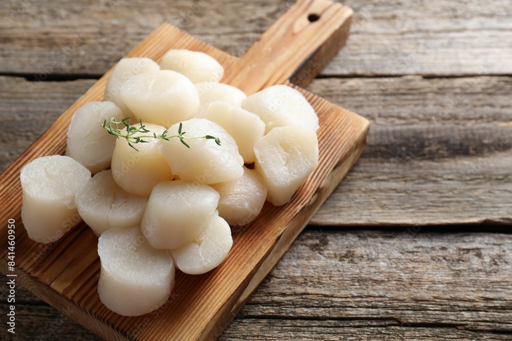 Fresh raw scallops and thyme on wooden table. Space for text Fresh raw scallops and thyme on wooden table. Space for text