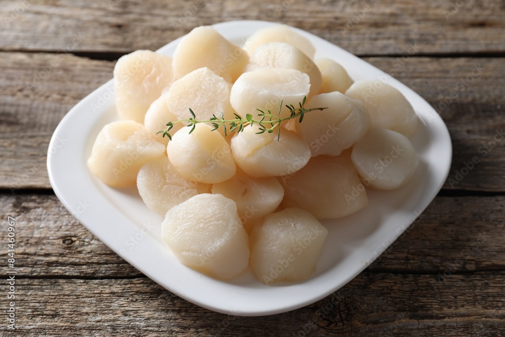 Fresh raw scallops and thyme on wooden table, closeup Fresh raw scallops and thyme on wooden table, closeup