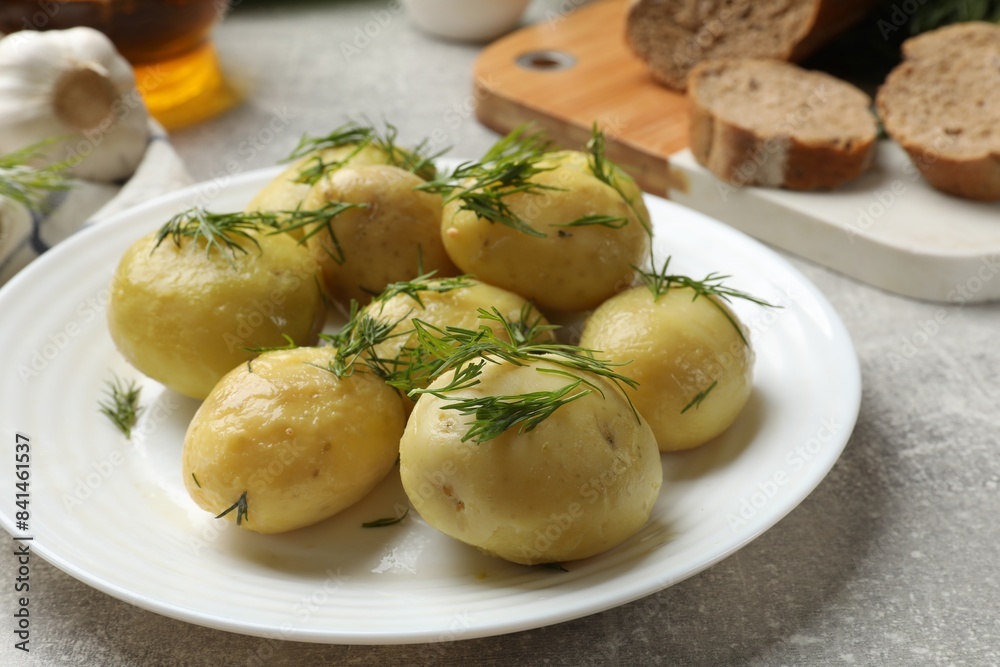 Tasty young boiled potatoes with dill on light grey table Tasty young boiled potatoes with dill on light grey table