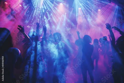 Under the vibrant glow of ultraviolet light, people are having fun in a club, dancing energetically on the stage