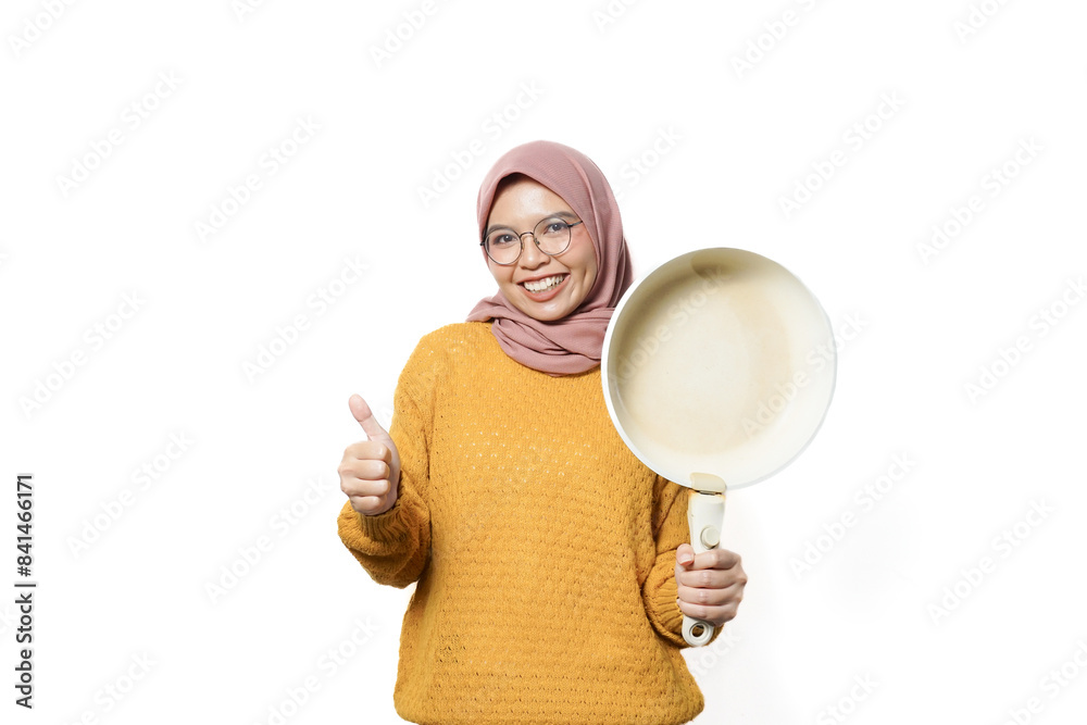 Smilling beautiful Asian woman holding pan while doing housework isolated over white background Smilling beautiful Asian woman holding pan while doing housework isolated over white background