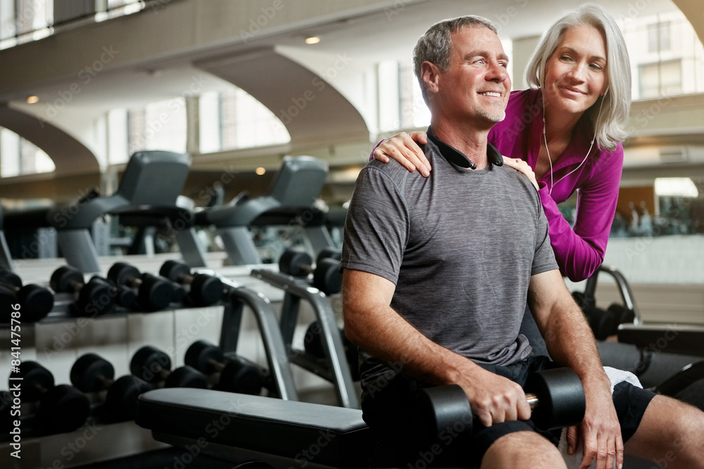 Mature couple, dumbbell and workout for fitness, care and happy with weightlifting for wellness at gym. People, man and woman with smile for motivation, training and exercise with chat for support
