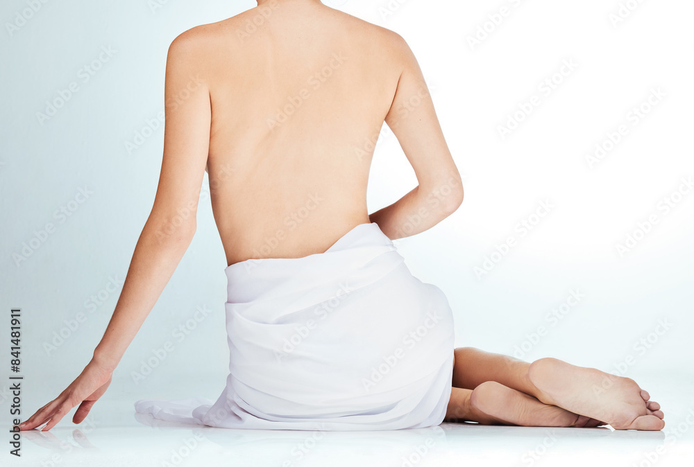 Woman, back and cosmetics in naked studio, wellness and selfcare or towel on white background. Female person, nude and body care for aesthetic, skincare and treatment for health or dermatology Woman, back and cosmetics in naked studio, wellness and selfcare or towel on white background. Female person, nude and body care for aesthetic, skincare and treatment for health or dermatology