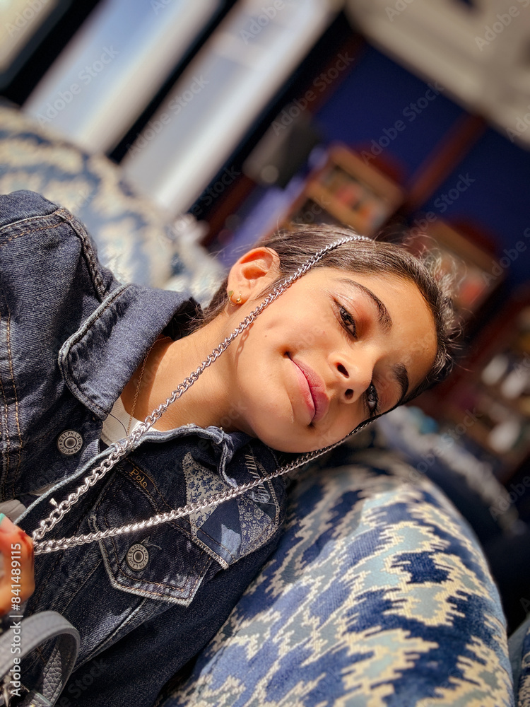A young girl peacefully resting with her eyes closed, capturing a moment of calm against the backdrop of a stylish lounge. A young girl peacefully resting with her eyes closed, capturing a moment of calm against the backdrop of a stylish lounge.