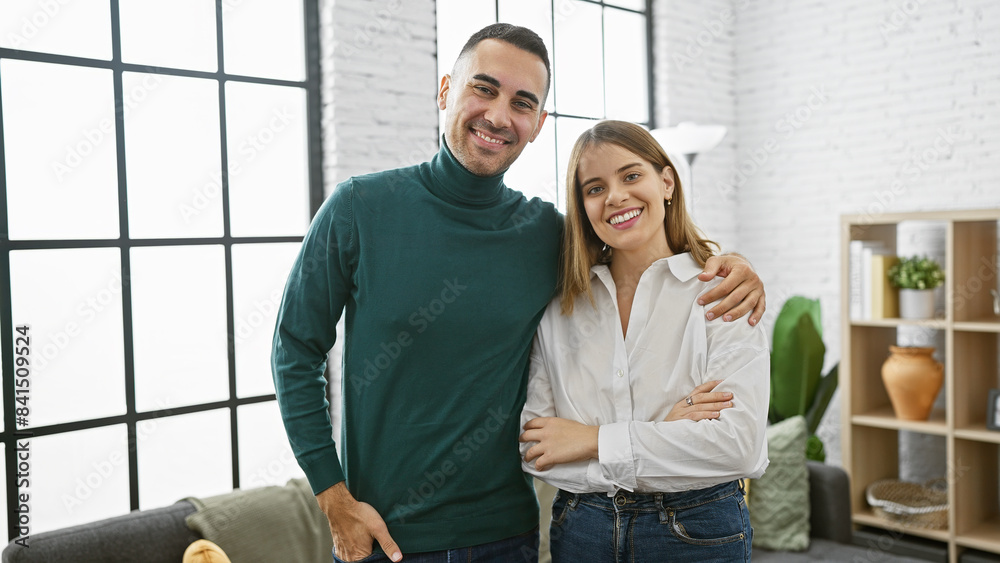 Obraz premium A smiling couple embraces warmly in a stylish living room, reflecting love and companionship in a modern home setting.