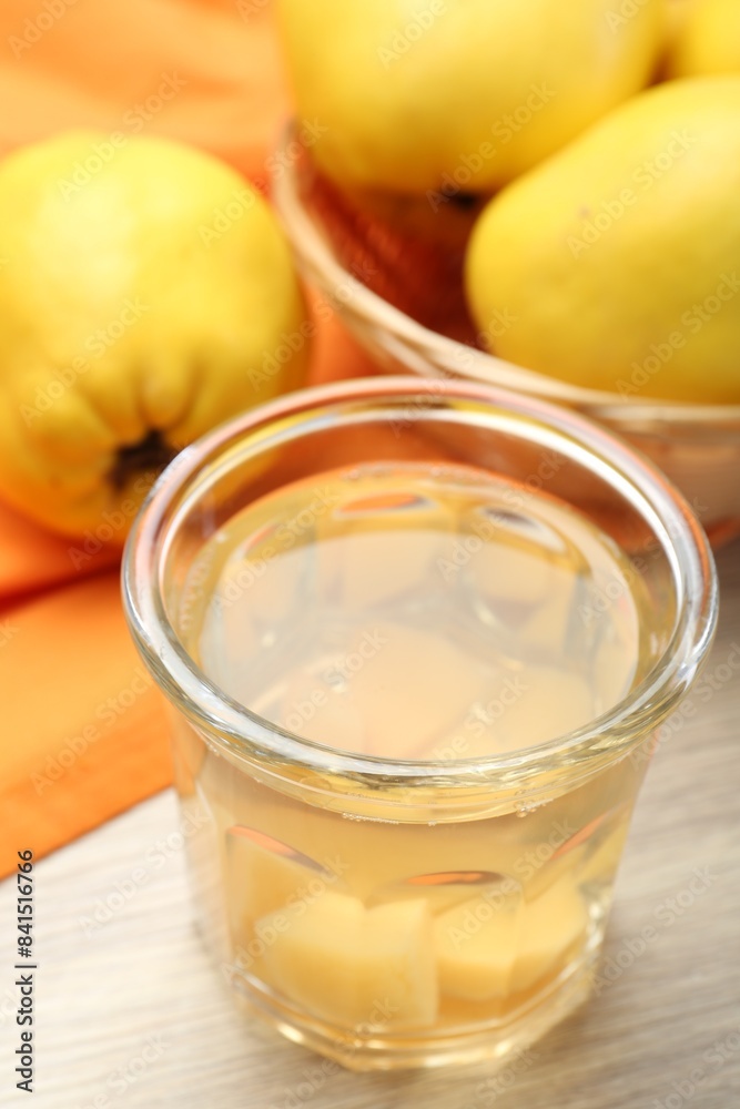 Delicious quince drink in glass and fresh fruits on wooden table, closeup Delicious quince drink in glass and fresh fruits on wooden table, closeup
