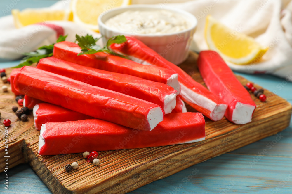 Tasty crab sticks, sauce and spices on light blue wooden table, closeup Tasty crab sticks, sauce and spices on light blue wooden table, closeup