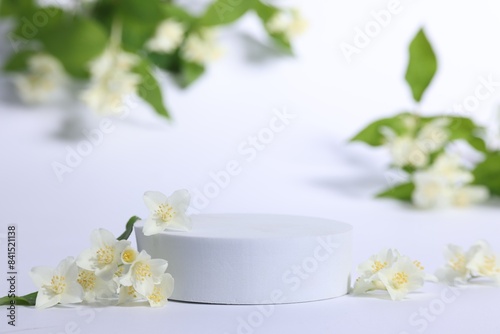 Presentation of product. Podium and beautiful jasmine flowers on white background
