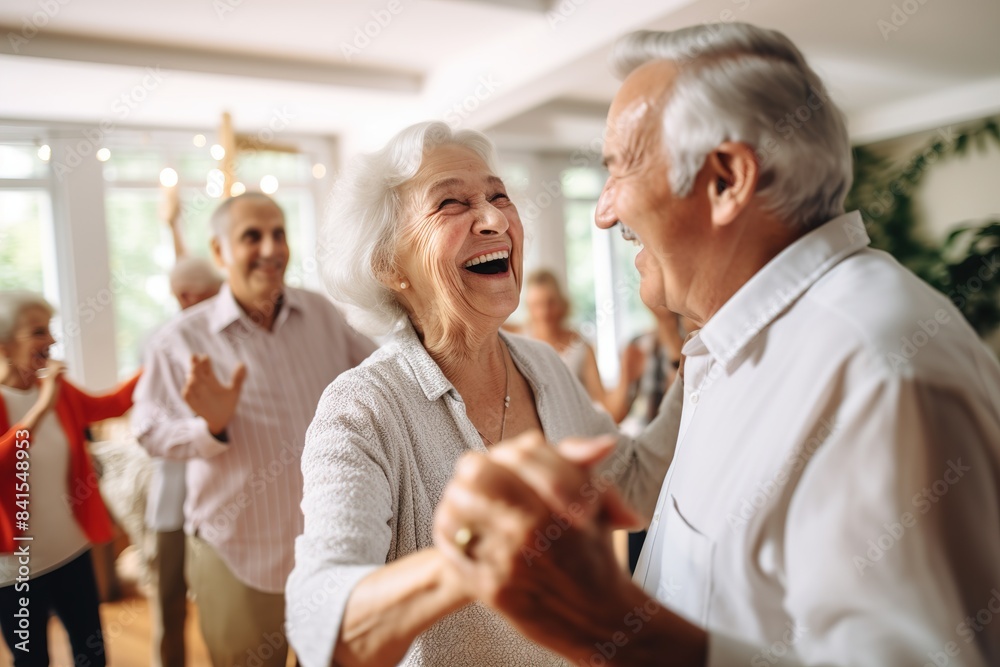 Obraz premium An elderly couple is dancing at a house party in an apartment for elderly friends, smiling and enjoying chatting with friends. Time for the elderly.