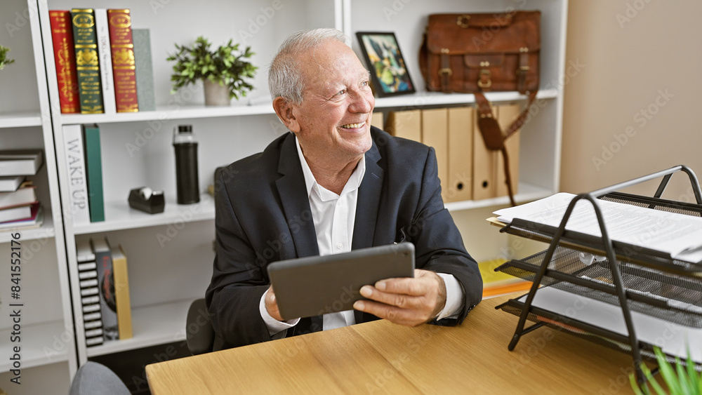 Confident and joyful senior man, a memorable boss with white hair, happily works online using touchpad at his elegant office desk, radiating success with every smile. Confident and joyful senior man, a memorable boss with white hair, happily works online using touchpad at his elegant office desk, radiating success with every smile.