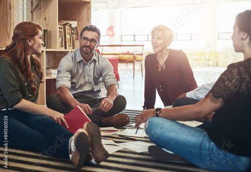 Group, circle or business people sitting on floor for collaboration, documents and notes for ideas. Teamwork, huddle or meeting with manager for company plan, discussion for strategy in office