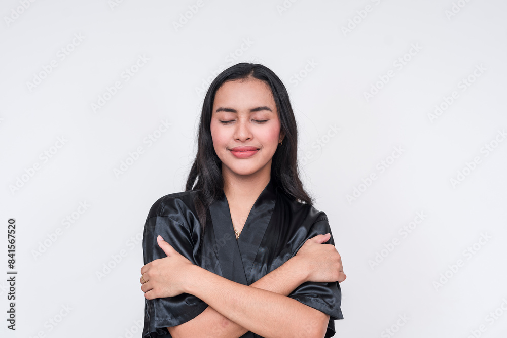 Asian woman in black silk bathrobe embracing self Asian woman in black silk bathrobe embracing self