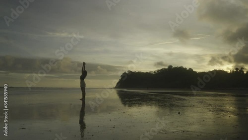 Woman practicing Yoga at sunrise