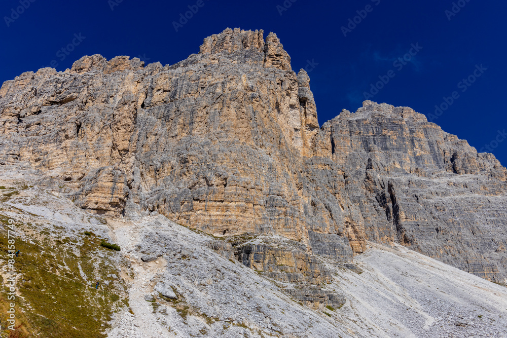 Dolomites beautiful alpine rock tower summits under blue sky in summer. Italian Alps mountains scenic landscape of rocky climbing walls in the high altitude majestic view of the cliff and green valley Dolomites beautiful alpine rock tower summits under blue sky in summer. Italian Alps mountains scenic landscape of rocky climbing walls in the high altitude majestic view of the cliff and green valley