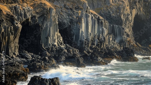 The rugged coastline dotted with tall angular basalt columns formed by the constant beating of the waves.