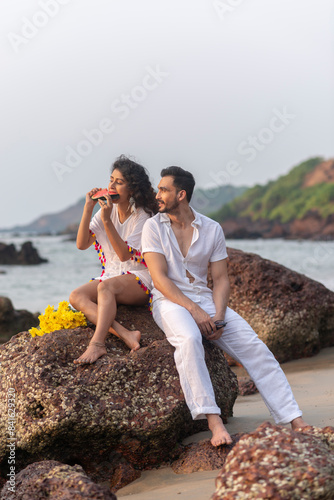 couple chilling by the beach wearing white clothes