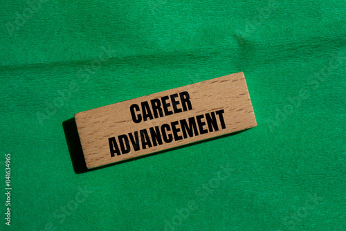 Career advancement message written on wooden block with green background. Conceptual career advancement symbol. Copy space. photo