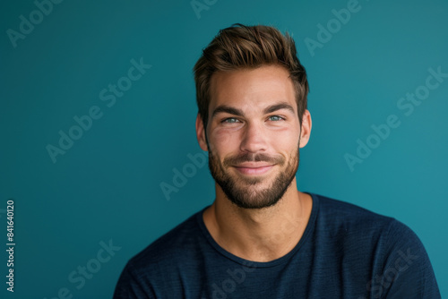 A close up portrait of a young man with a subtle smile