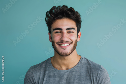 A close up portrait of a young man with a subtle smile