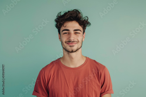 A close up portrait of a young man with a subtle smile