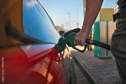 Petrol pum nozzle filling car tank with gas