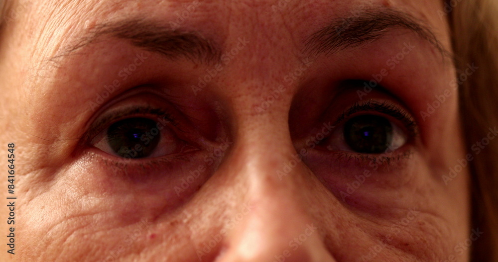 Senior woman eyes close-up watching TV screen Senior woman eyes close-up watching TV screen