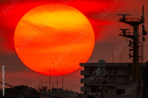 海峡の向かいの団地に落ちる夕日と前を横切る船のシルエット20240525-2 photo