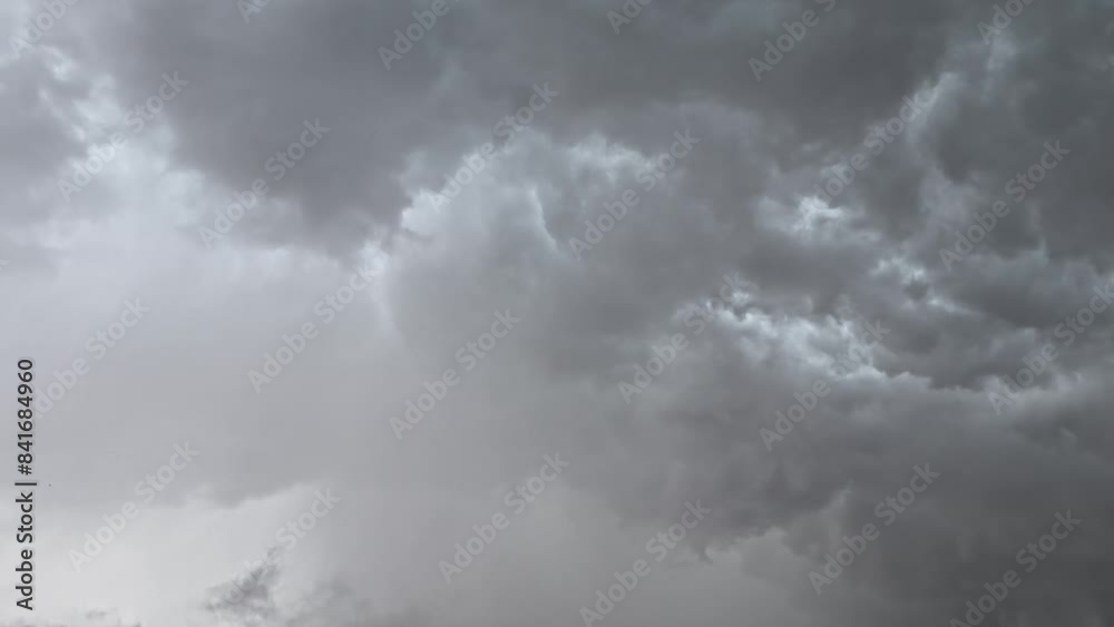 The gray clouds in the overcast sky are occasionally illuminated by flashes of lightning