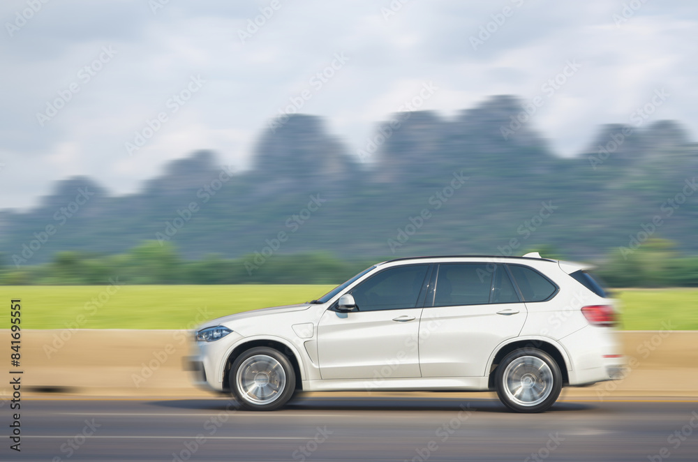 White car running at speed in Thailand's mountain landscape roads at daylight White car running at speed in Thailand's mountain landscape roads at daylight