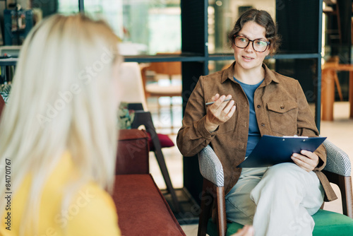 A female psychologist advises a client. Portrait of a professional modern woman. HR hires and conducts interviews. photo