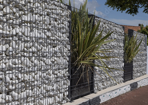 Brise-vue en gabions de galets blancs en aluminium d'une maison	 photo