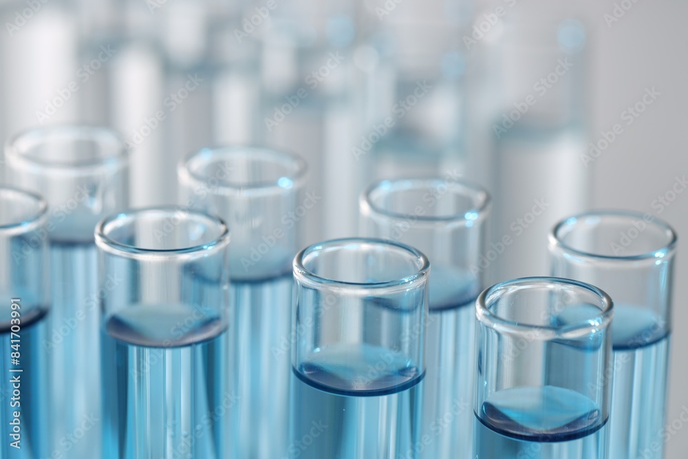 Many glass test tubes on light background, closeup Many glass test tubes on light background, closeup