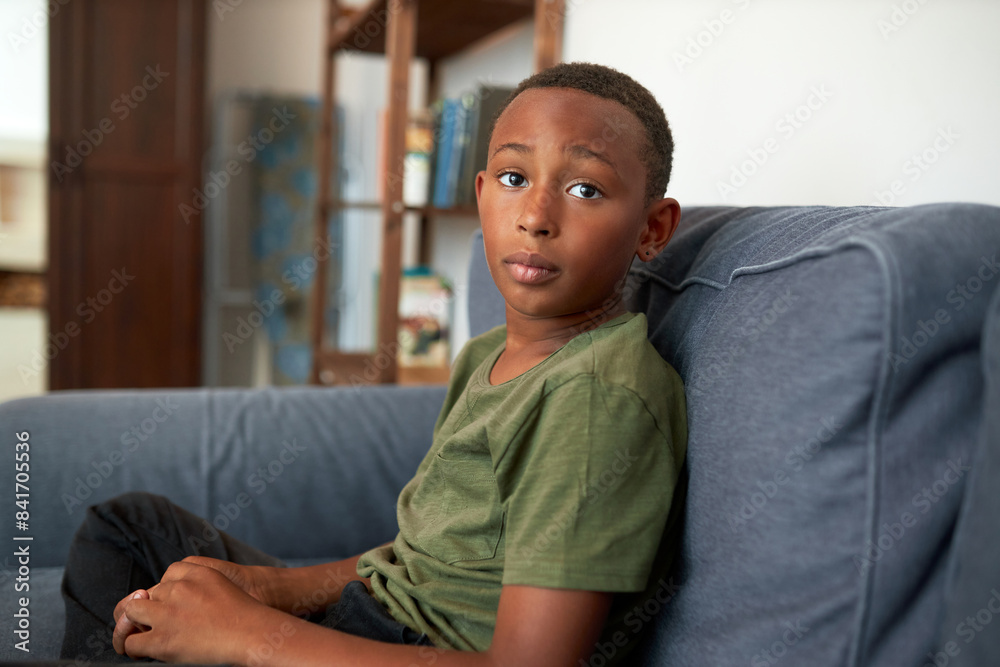 Worried black teenager in casual clothes sitting on couch in his room as punishment for bad behavior, looking aside with hope waiting for forgiveness of his mom, feeling guilty and stressed Worried black teenager in casual clothes sitting on couch in his room as punishment for bad behavior, looking aside with hope waiting for forgiveness of his mom, feeling guilty and stressed