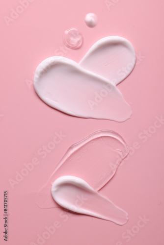 Samples of face cream on pink background, top view