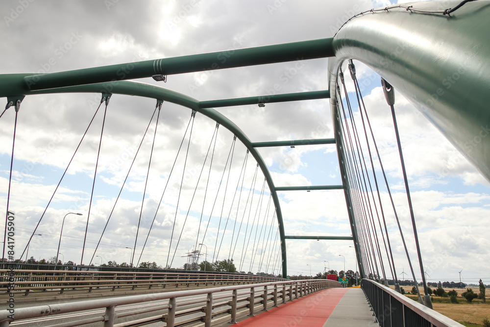 Fototapeta premium Car on a bridge, urban landscape, wide angle. Automobile on a highway, urban transportation, road curve