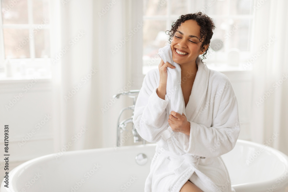 Happy African American lady drying face with towel, enjoy doing facial skincare ritual in the morning in bathroom. Woman enjoying beauty routine Happy African American lady drying face with towel, enjoy doing facial skincare ritual in the morning in bathroom. Woman enjoying beauty routine