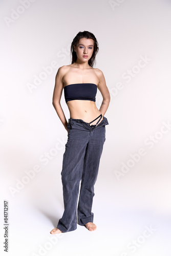 Young woman with wet hair in trendy strapless top and pants.