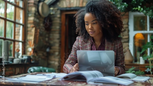 Young Woman Working On Laptop in Cafe With Warm Lighting