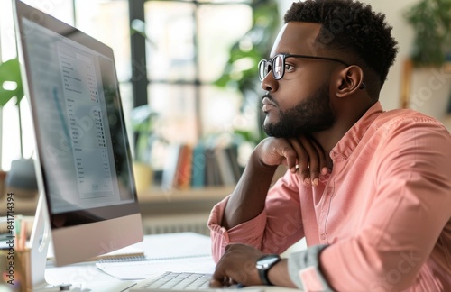 Focused Man Working at a Computer in a Modern Office