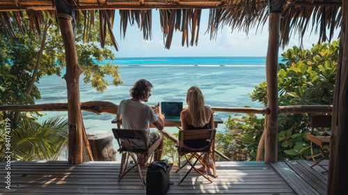 Couple working remotely from a beachside eco-resort © NooPaew