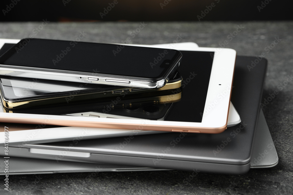 Stack of electronic devices on grey table, closeup Stack of electronic devices on grey table, closeup