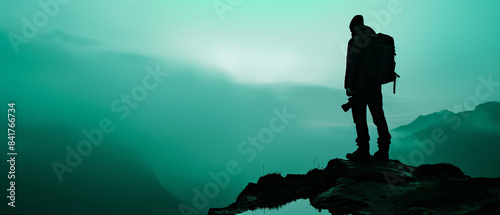 A photographer silhouetted against the aurora borealis. with copy and space photo