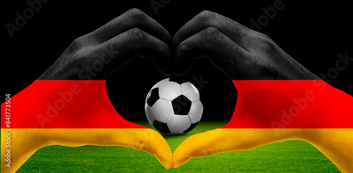 Hand formt ein Herz um Fussball