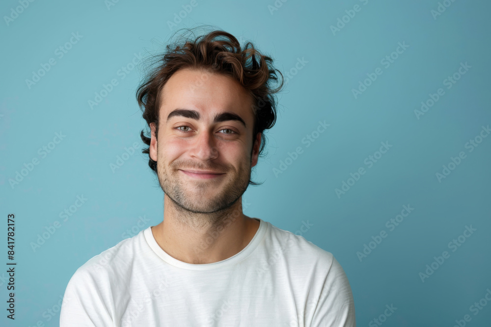 A close up portrait of a young man with a subtle smile