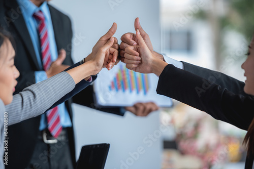 A group of business people giving thumbs up in a meeting. photo