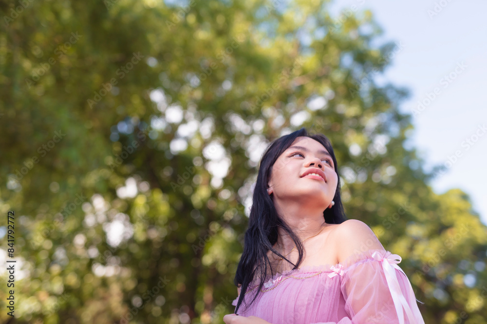 Young woman in pink dress enjoying sunny day in park Young woman in pink dress enjoying sunny day in park