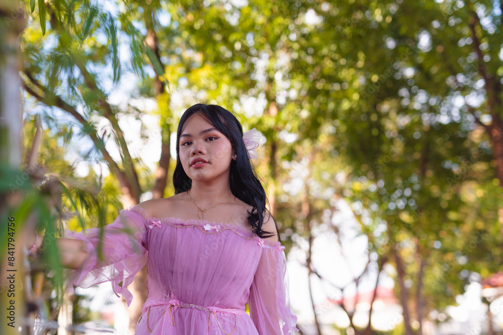 Curious young woman wearing pink dress exploring lush green park Curious young woman wearing pink dress exploring lush green park